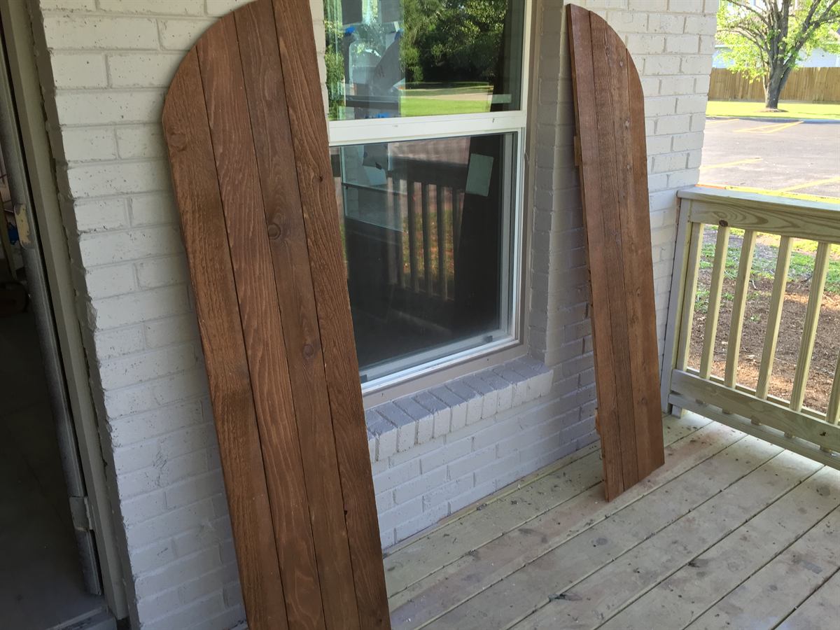 Custom arched wood shutters with a rich stain